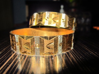 Golden Bangles on a wooden table