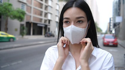 Concept of pollution prevention. The girl is showing how to properly use the mask. 4k Resolution.