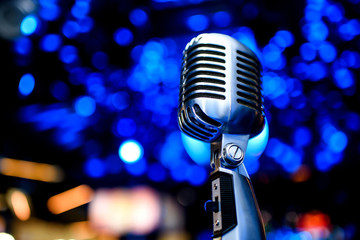 Karaoke background.Silver vintage microphone on bokeh.Close-up of retro microphone at concert.Professional microphone
