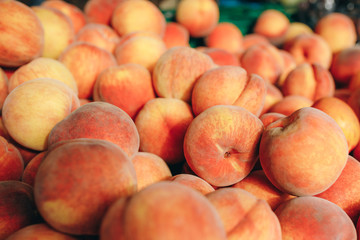 Peaches close-up on a shop window. A lot of delicious and beautiful peaches. Selective focus.