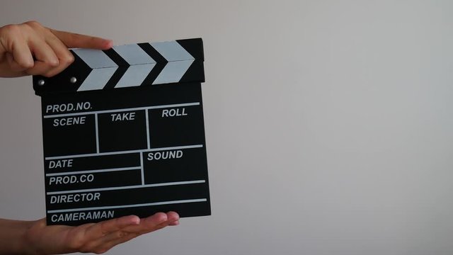 Close up female hold in hand wooden director clear empty black film making clapperboard isolated on gray background. 