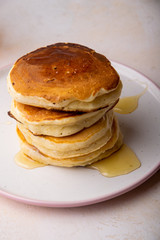 a stack of fresh pancakes with syrup on a plate