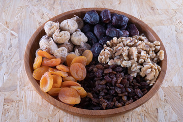 dried apricot, nuts and raisins in a wooden cup