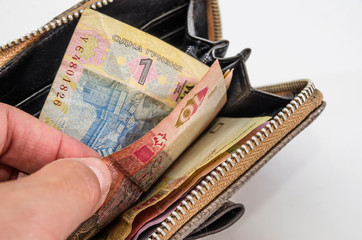 Hand takes out hryvnia from the wallet. White background. Close-up.