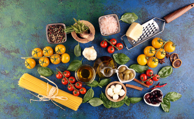 Fototapeta na wymiar Italian food background with herbs and spices, vine tomatoes, basil, spaghetti, olives, parmesan, olive oil, garlic, peppercorns and fresh rosemary