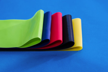 colored rubber bands for fitness on a blue background. Close-up.