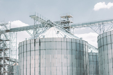 Building for storage, drying and processing of raw harvest products: grain, wheat, corn. Modern agriculture silos facility building. Crop processing plant. Grain warehouse tower. Agriculture business © Artem