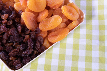 various dried fruits, apricot, raisins on a green tablecloth