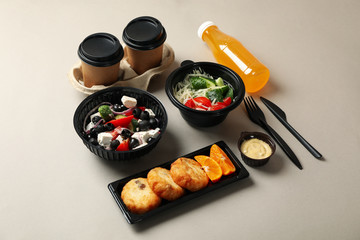 Food delivery. Food in takeaway boxes on gray background