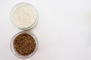 rice and buckwheat in glass jars on white. View from above. Copy space. A place for text.