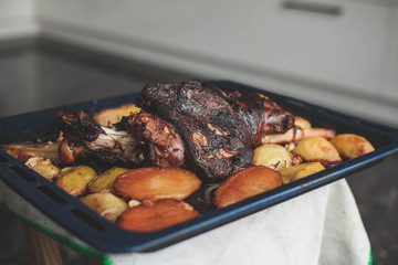 roast leg with potatoes in the oven