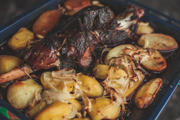 roast leg with potatoes in the oven