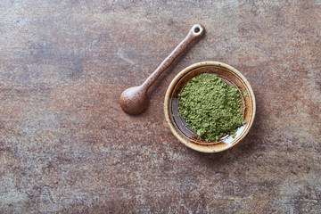 Fototapeta na wymiar Powdered matcha green tea on rustic stone background. Top view.