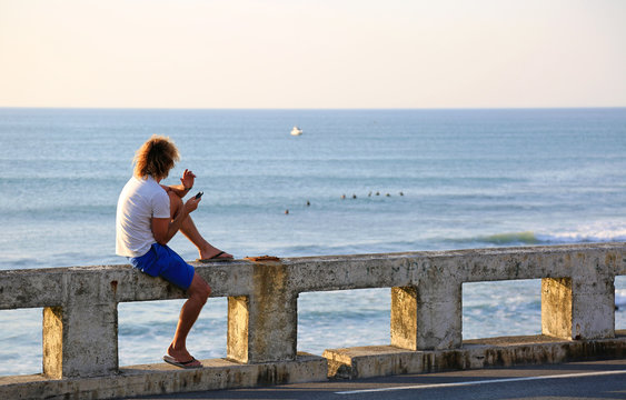 hombre joven rubio sentado mirando al mar atardecer U84A4486-as20