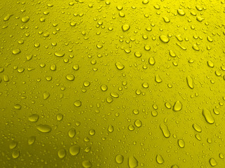 Drops of water on a yellow metal surface, beautiful background after rain