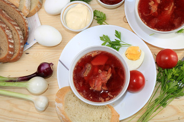 Traditional homemade borsch with egg and bread on a sunny table, place for text and menu, copy space. The concept of healthy and natural food, cooking dinner at home, selective focus.