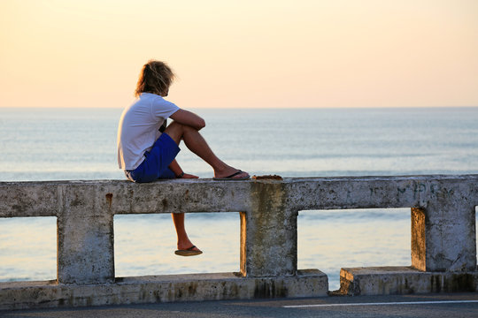 hombre joven rubio sentado mirando al mar atardecer U84A4570-as20