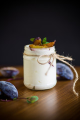 Homemade sweet yogurt with slices of ripe plums in a glass