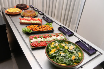 Lunch feast with different foods. Salads and desserts
