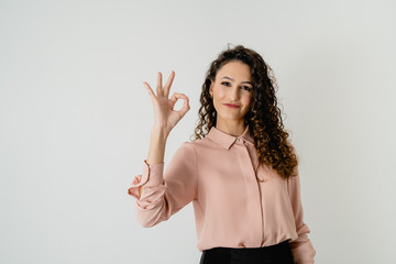 chica joven elegante tiene la mano haciendo el gesto de ok