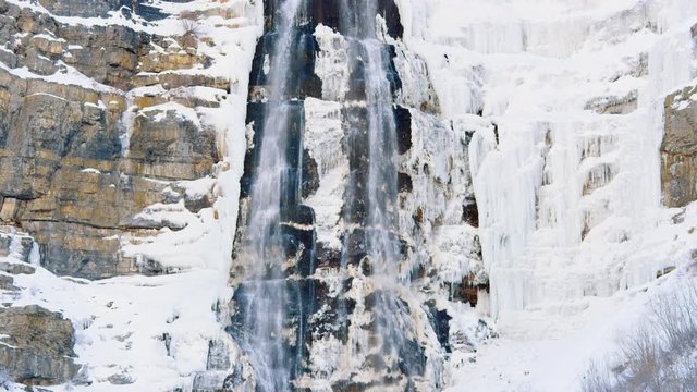 Tilt up ice covered waterfall Bridal Veil Falls in Provo Utah in slow motion