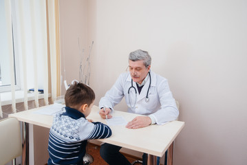 A young boy is listened to and treated by an experienced doctor in a modern clinic. A virus, and an epidemic