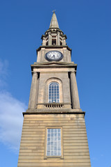 Fototapeta na wymiar Tall Stone Spire of Public Clock Tower Seen from Below 
