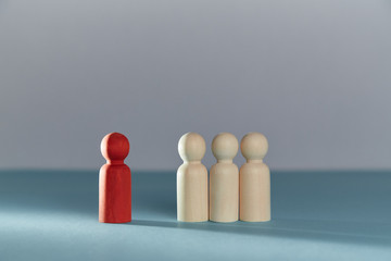 Social exclusion. Bullying, court of lynching. Loneliness and isolation. Wooden figures and one red person stands alone