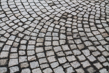 Fototapeta premium Gray mosaic of stone on the floor. Many square pieces of stone are laid out in a circle shape. Old texture background.