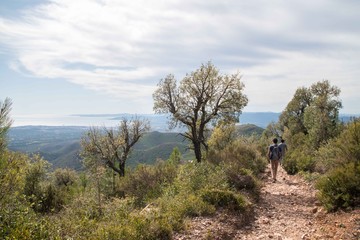 Obraz premium Hiker walking down a rocky trail in the hills in Cannes district