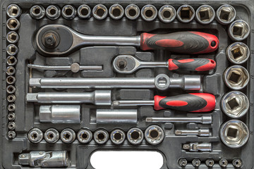 Men tools background. Worker tools and equipment close-up. A set of wrenches and screwdrivers are laid out in the cells of the box.