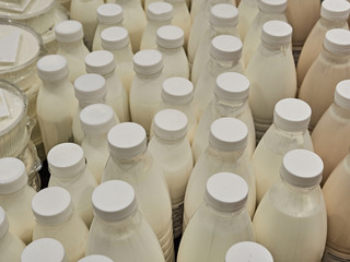 Bottled milk on a shelf in a supermarket. Many bottles
