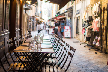 Empty outdoor seating with nicely arrange glasses, in a cozy street