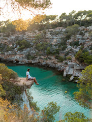 Young male at beautiful Cala Pi, Majorca with turquoise water at sunset