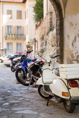 Fototapeta na wymiar Parked motorbikes in the alley of historical town Bergamo, Lombardy, Italy.