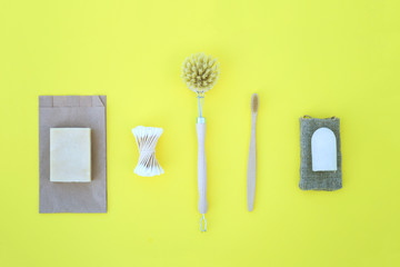 Eco product on the yellow background with wooden goods such toothe brush cotton buds