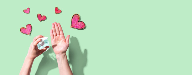 Applying sanitizer gel for cleaning hands with heart drawings
