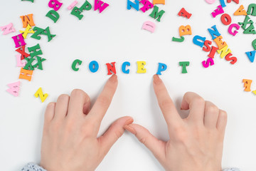 Creative thinking and innovative approach. Female hands spread out of colored letters the word concept