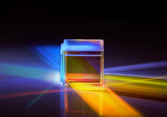 multicolored rays of light reflected by a crystal cube 