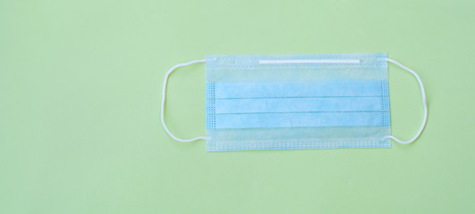Medical mask on a green background. Concept of medicine, protection from infection, protection from coronavirus