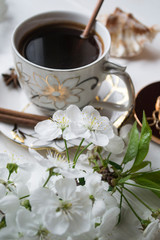 Obraz na płótnie Canvas A cup of coffee and blossom branches. Spring morning.
