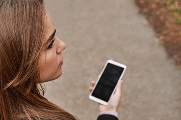 Girl outdoors looking for a place and paving the way. Uses a phone and gps app for navigation to...