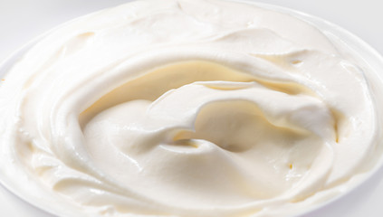 Fototapeta na wymiar Whipped sour cream in a white plate
