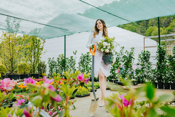 Young beautiful woman gardener planting flowers, enjoying her work. Space for text