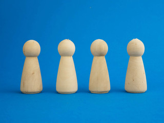 wooden figurines standing on a blue background