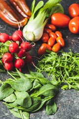 Different vegetables. Arugula, radishes, spinach, red peppers, tomatoes and pak choi.