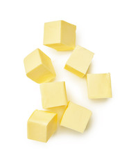 Pieces of butter isolated on white background. Top view of butter cubes. - obrazy, fototapety, plakaty