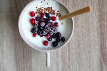 Bowl of rice porridge with seeds and fozen berries. Top view.