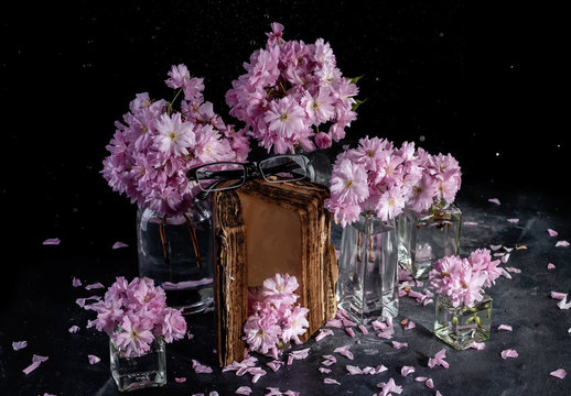 Cherry blossom, sakura flowers in a glass jar on a old book