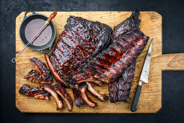 Barbecue veal spare loin ribs St Louis cut with hot honey chili marinade burnt as top view on a rustic wooden cutting board